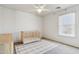 Bedroom with ceiling fan, window, gray carpet, and a wooden crib at 18260 W Bridger St, Surprise, AZ 85388