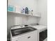 Bright laundry room with front load washer, dryer and shelving at 18260 W Bridger St, Surprise, AZ 85388