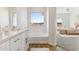 Bathroom with soaking tub and vanity, offering a view of the bedroom at 20235 W Highland Ave, Litchfield Park, AZ 85340