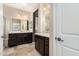 Double vanity bathroom with dark wood cabinets and a large mirror at 20652 N Wishing Well Ln, Maricopa, AZ 85138