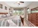 Bright bedroom with a wooden bed frame, large windows, and a dresser at 20652 N Wishing Well Ln, Maricopa, AZ 85138