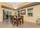 Bright dining room with a table and chairs, access to a patio, and decorative wall art at 20652 N Wishing Well Ln, Maricopa, AZ 85138