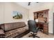 Charming home office with a desk and comfortable couch at 20652 N Wishing Well Ln, Maricopa, AZ 85138