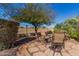 Small patio with metal table and chairs, surrounded by gravel and shrubs at 20652 N Wishing Well Ln, Maricopa, AZ 85138