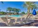 Community pool with lounge chairs and palm trees in sunny area at 20652 N Wishing Well Ln, Maricopa, AZ 85138