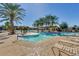 Relaxing community pool area with palm trees and plenty of lounge chairs at 20652 N Wishing Well Ln, Maricopa, AZ 85138