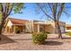 Tan one-story house with red tile roof, a pergola, and well-manicured landscaping at 25636 S Howard Dr, Sun Lakes, AZ 85248