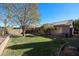 Large backyard with grassy area, mature tree, and patio at 2828 E Blackhawk Dr, Phoenix, AZ 85050