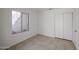 Bright bedroom with tile floors, large window, and sliding door closet at 2828 E Blackhawk Dr, Phoenix, AZ 85050