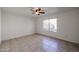 Bedroom with tile floors, a window overlooking the backyard, and ceiling fan at 2828 E Blackhawk Dr, Phoenix, AZ 85050