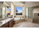 Spa-like bathroom with soaking tub, double vanity, and glass block shower at 30014 N Baker Ct, Scottsdale, AZ 85262