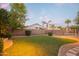 Green grassy backyard with swimming pool and palm trees at 306 E Dennisport Ct, Gilbert, AZ 85295