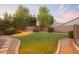 Landscaped backyard with grassy lawn and stone pathway at 306 E Dennisport Ct, Gilbert, AZ 85295