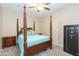 Bedroom with wooden post bed, ceiling fan, and safe at 306 E Dennisport Ct, Gilbert, AZ 85295