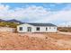 Rear view of a single-story house with a white exterior and dark gray roof at 3390 S Yaqui Ln, Gold Canyon, AZ 85118