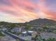 Aerial view of a luxury home showcasing the desert landscape and colorful sunset at 37178 N Winding Wash Trl, Carefree, AZ 85377