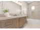 Stylish bathroom with a wood vanity, large mirror, decorative tile, and a combined tub and shower at 37178 N Winding Wash Trl, Carefree, AZ 85377