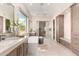 Elegant bathroom with a soaking tub, dual vanities, and a walk-in shower with glass door at 37178 N Winding Wash Trl, Carefree, AZ 85377