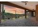 Inviting covered patio with desert views, featuring stone columns, ceiling fans, and pavers at 37178 N Winding Wash Trl, Carefree, AZ 85377