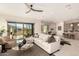 Open-concept living room features a neutral color palette, modern ceiling fan, and natural light streaming through sliding glass doors at 37178 N Winding Wash Trl, Carefree, AZ 85377