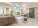 Spa-like main bathroom with a soaking tub, dual vanities, and a glass-enclosed shower at 37178 N Winding Wash Trl, Carefree, AZ 85377