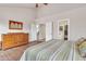 Main bedroom with wood floors, striped bedding, and access to bathroom and stairs at 4028 N Ranier --, Mesa, AZ 85215