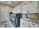 Functional laundry room with front-load washer and dryer and granite counters at 4053 E Zion Way, Chandler, AZ 85249