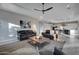 Living room with leather sofas, media center, stylish ceiling fan, and open concept to the kitchen at 4053 E Zion Way, Chandler, AZ 85249