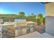 Outdoor kitchen with stainless steel grill, sink, refrigerator, and stone counter, perfect for backyard entertaining at 4053 E Zion Way, Chandler, AZ 85249