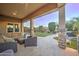 Relaxing covered patio featuring a stone column, plush seating, and a view of the manicured backyard at 4053 E Zion Way, Chandler, AZ 85249