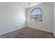 Charming bedroom with carpet, an arched window and blinds at 41838 W Chatham Pl, Maricopa, AZ 85138