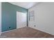 Bedroom with teal accent wall, carpet, and double closet at 41838 W Chatham Pl, Maricopa, AZ 85138