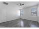 Bright bedroom with grey wood-look floors and ceiling fan at 41838 W Chatham Pl, Maricopa, AZ 85138