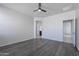 Large bedroom with grey wood-look floors and ceiling fan at 41838 W Chatham Pl, Maricopa, AZ 85138