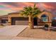 Tan house with a brown garage door and palm tree in the front yard at 41838 W Chatham Pl, Maricopa, AZ 85138