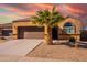 Tan house with a brown garage door and a lush green lawn at 41838 W Chatham Pl, Maricopa, AZ 85138