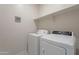 Laundry room with washer, dryer, and overhead shelving at 41838 W Chatham Pl, Maricopa, AZ 85138