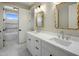 Modern bathroom featuring dual sinks, white marble countertops, gold framed mirrors, and elegant fixtures at 4420 E Glenrosa Ave, Phoenix, AZ 85018