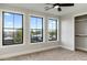 Bright bedroom with ample natural light from three large windows, featuring a ceiling fan and neutral carpet at 4420 E Glenrosa Ave, Phoenix, AZ 85018