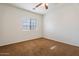 Bright bedroom with ceiling fan and brown carpet at 45354 W Horse Mesa Rd, Maricopa, AZ 85139