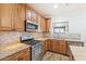 Modern kitchen features granite countertops, wood cabinets, and stainless steel appliances at 45354 W Horse Mesa Rd, Maricopa, AZ 85139