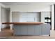 Modern kitchen featuring sleek cabinetry, a gray island with butcher block, and stainless appliances at 4575 N Phoenician Blvd # 2, Scottsdale, AZ 85251