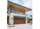 Contemporary two-story home featuring a stone facade, balcony, and a modern wood garage door at 4575 N Phoenician Blvd # 4, Scottsdale, AZ 85251