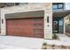 Modern wood garage door with stone surround and sidelight window, next to desert landscaping at 4575 N Phoenician Blvd # 4, Scottsdale, AZ 85251