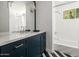 Clean bathroom with marble countertop, navy vanity, and bathtub at 5328 N 46Th St, Phoenix, AZ 85018