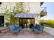 Patio furniture under a striped awning, nestled against a vine covered wall at 5328 N 46Th St, Phoenix, AZ 85018