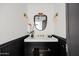 Chic powder room with marble vanity, black lower cabinets, and unique mirror at 5328 N 46Th St, Phoenix, AZ 85018