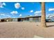 House exterior showcasing gray brick, modern garage door, and palm tree at 6702 E Adobe St, Mesa, AZ 85205