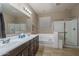 Modern bathroom with double sinks, a bathtub, and a shower at 7934 W Andrea Dr, Peoria, AZ 85383