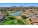 Picturesque aerial view of the golf course, pond, and neighborhood, with the mountains as a backdrop at 8243 E Cortez Dr, Scottsdale, AZ 85260